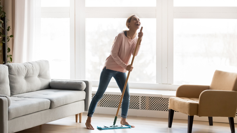 zadowolona kobieta sprząta podłogę